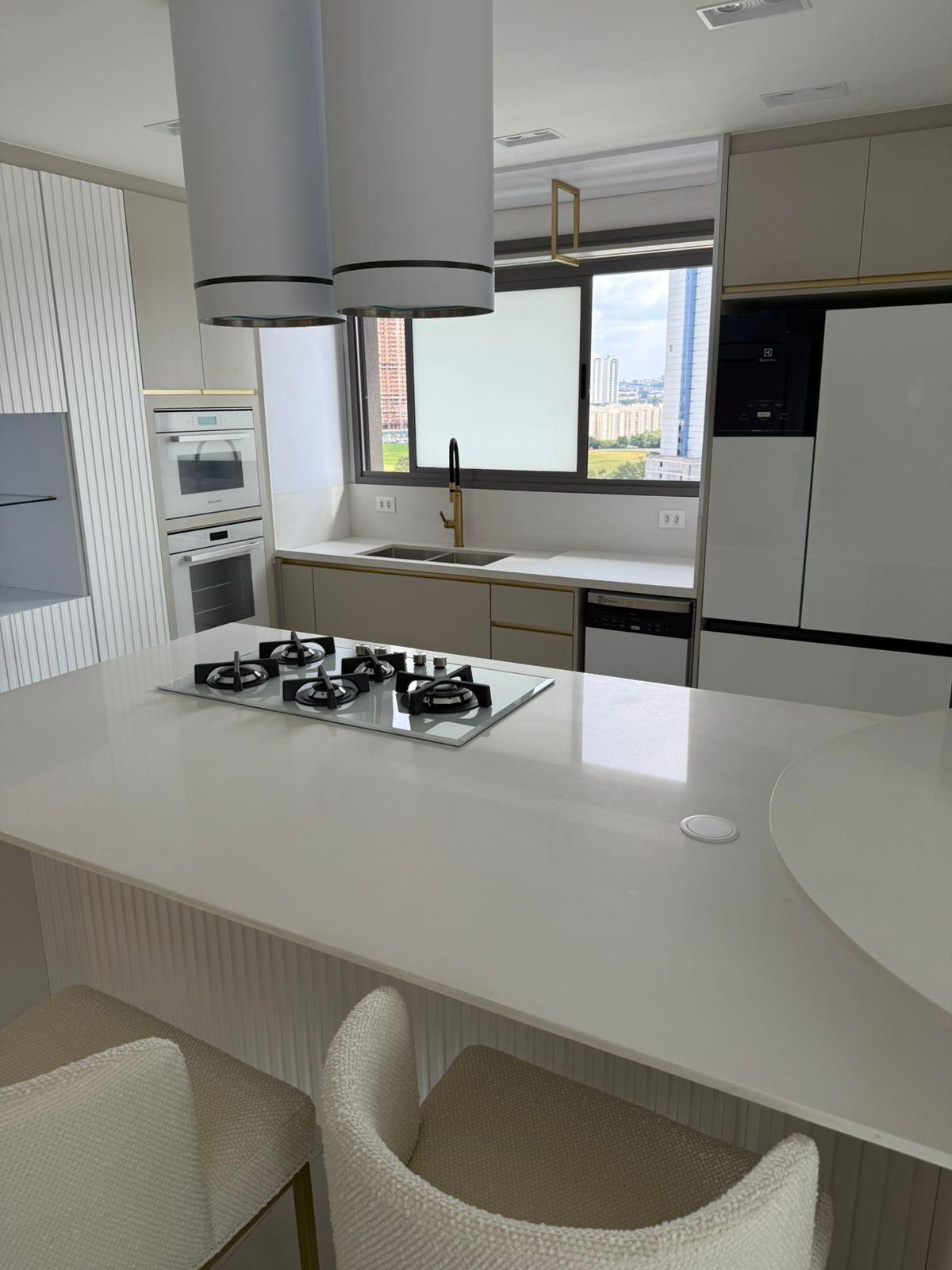 Cozinha com ilha clara e cooktop integrado