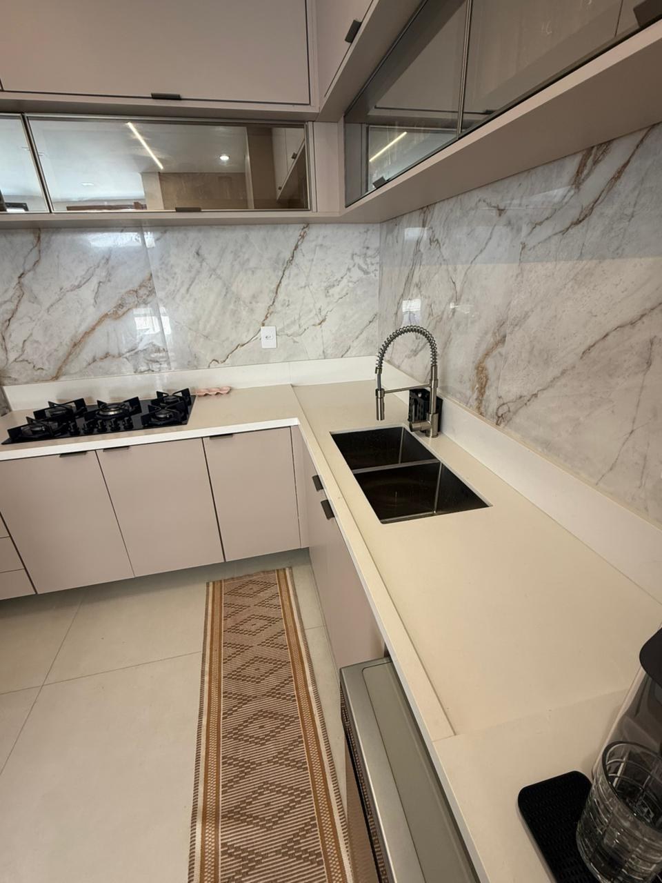 Cozinha clara com bancada em L e frontão revestido