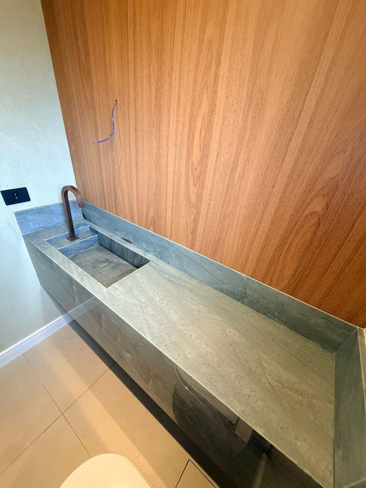 Lavabo com bancada em pedra e iluminação integrada